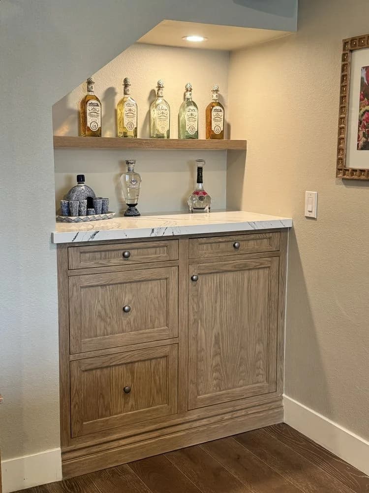 Custom home bar with built-in cabinetry, open shelving, and stone countertop in Oxnard, CA