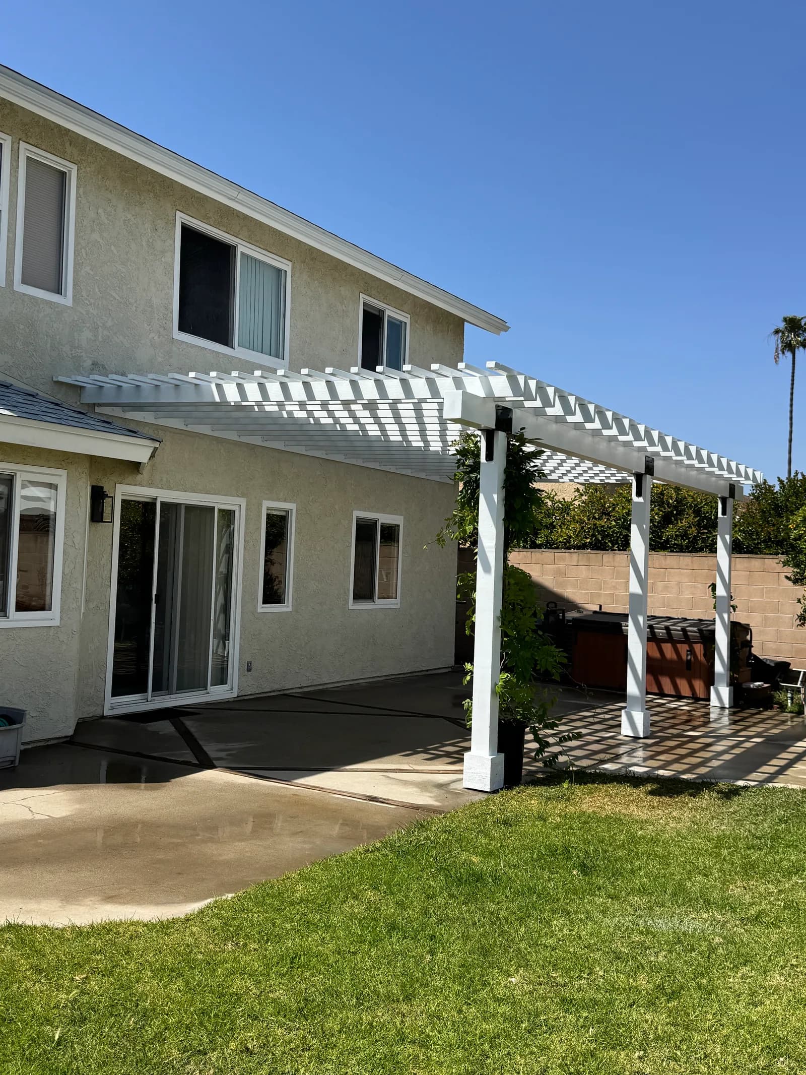 Backyard pergola build with stained timber rafters and concrete patio foundation in Oxnard, CA